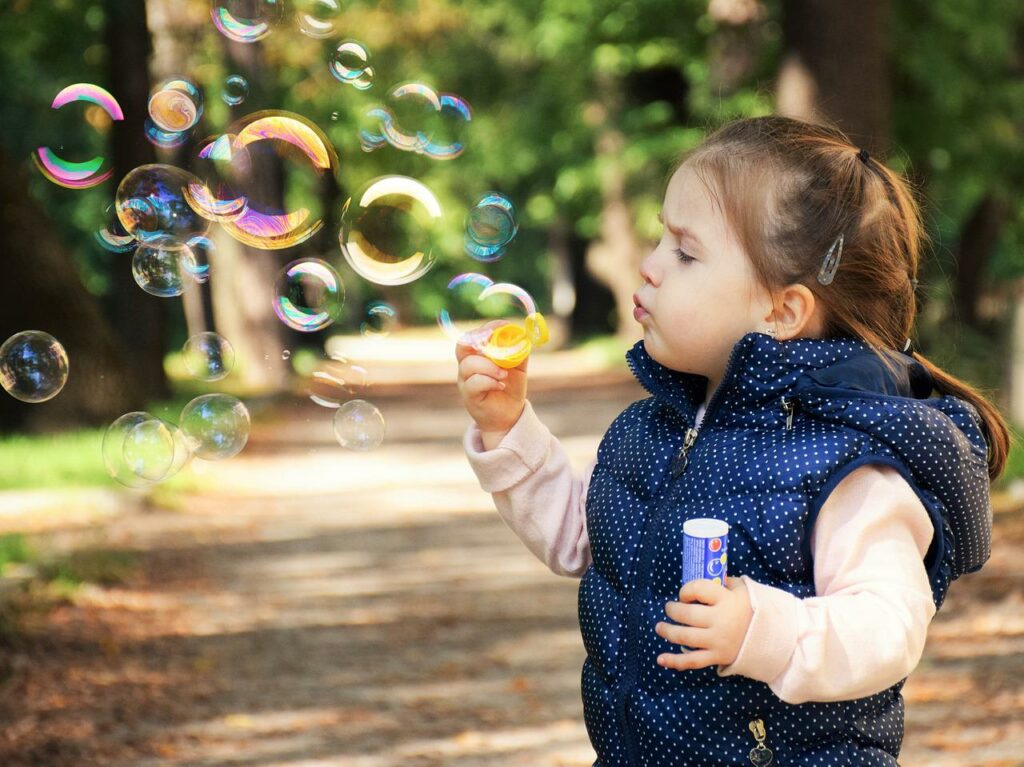 nachdenkliches Kind spielt mit Seifenblasen Körperpositivität Kindern beibringen So gelingt es