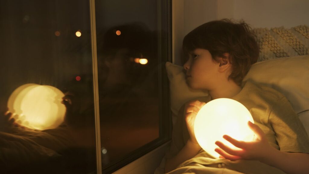 Kind liegt im Bett nachts Nachtlicht Nachtlicht für Kinder Vorteile im Blick